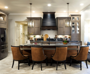 Brown custom cabinets with a mitered door with a black venthood and orange barstools