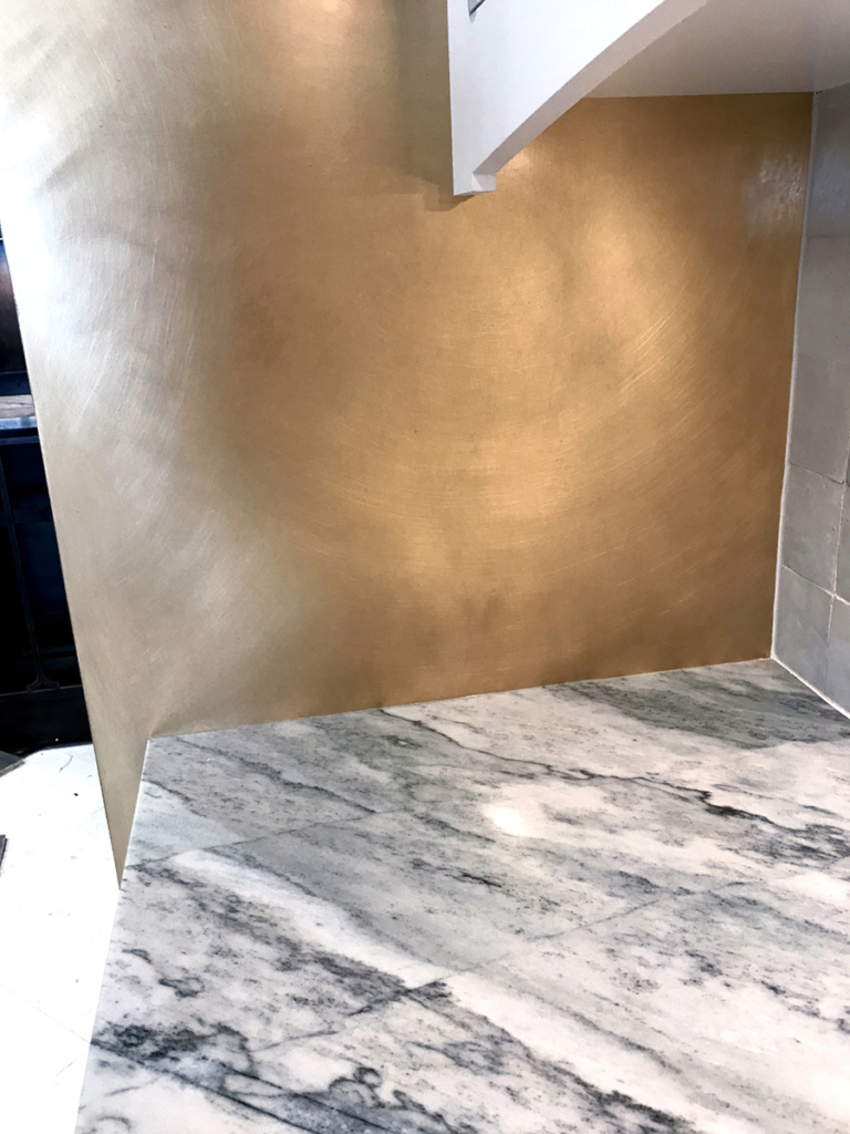Brass panels flanking oven components