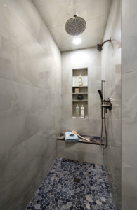 Curbless walk-in shower with quartzite seating and bottle niches