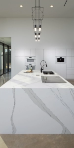 Waterfall countertop viewed from the end, Custom flat white cabinets in the background.