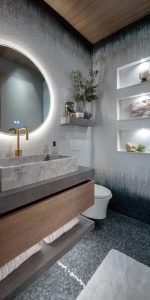 Floating vanity with round mirror with ombre tiled wall and wall niches