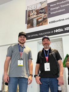 Scott and Ryan with Edmond Kitchen and Bath In front of a sign showing the kitchen they built.