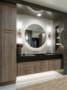 Lit round mirror atop the thickened quartz counter over our floating vanity