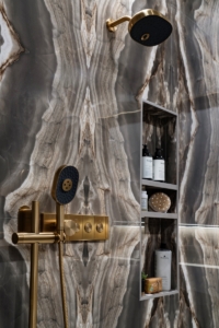 Bottle niche designed into the book matched stone tiles in this shower renovation