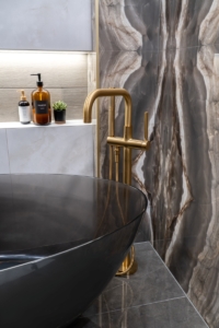 Gold free standing tub filler with infinity niche behind designed for this bathroom remodel