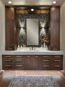 Her floating vanity with tower storage, wall sconces, and soffit lighting