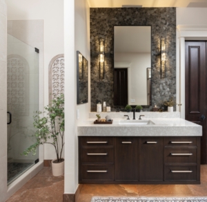 His floating vanity with full wall tile backsplash, framed mirror, and wall sconces in this remolded space