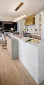 Luxury kitchen remodel with custom cabinetry and brass vent hood