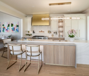 Premium kitchen remodel with custom cabinetry, brass venthood, custom lighting, and reeded doors