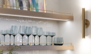 Luxury floating shelves with integrated lighting and brass railing designed by Edmond Kitchen & Bath