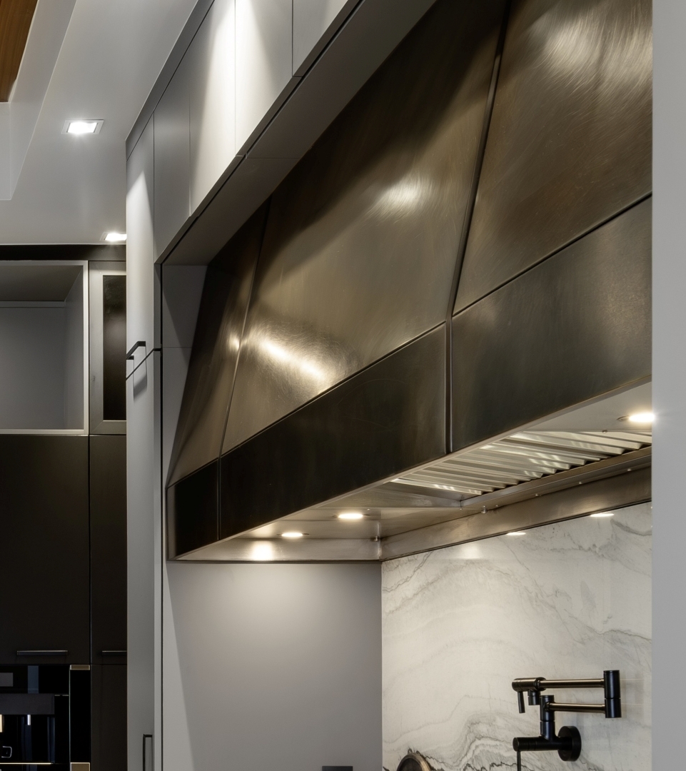 Custom fabricated brass/bronze kitchen venthood with stainless insert and custom lighting