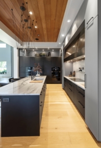 Luxury modern kitchen design with flat-black and grey cabinetry and bronze hood