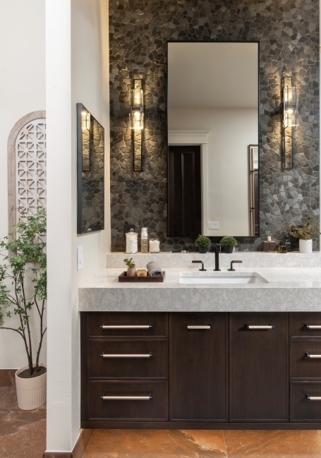 floating vanity with wall sconces next to shower