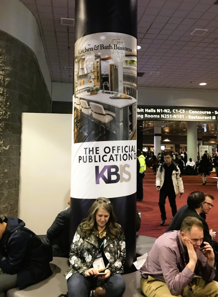 kitchen project on cover of magazine posted to support column with the designer sitting in front