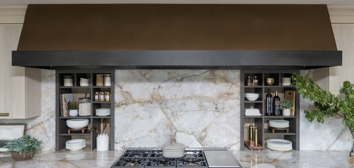 Custom bronze venthood designed and built above these in-wall storage niches for the kitchen in this whole home remodel