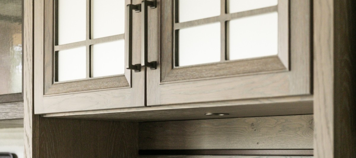 Detail image of custom cabinetry showing integrated lighting, side columns, and tight reveals
