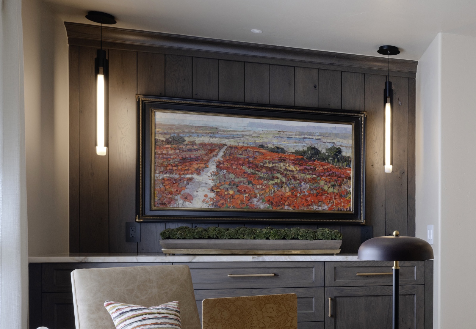 Custom office credenza beneath stained wood wall planking and decorative pendant lights