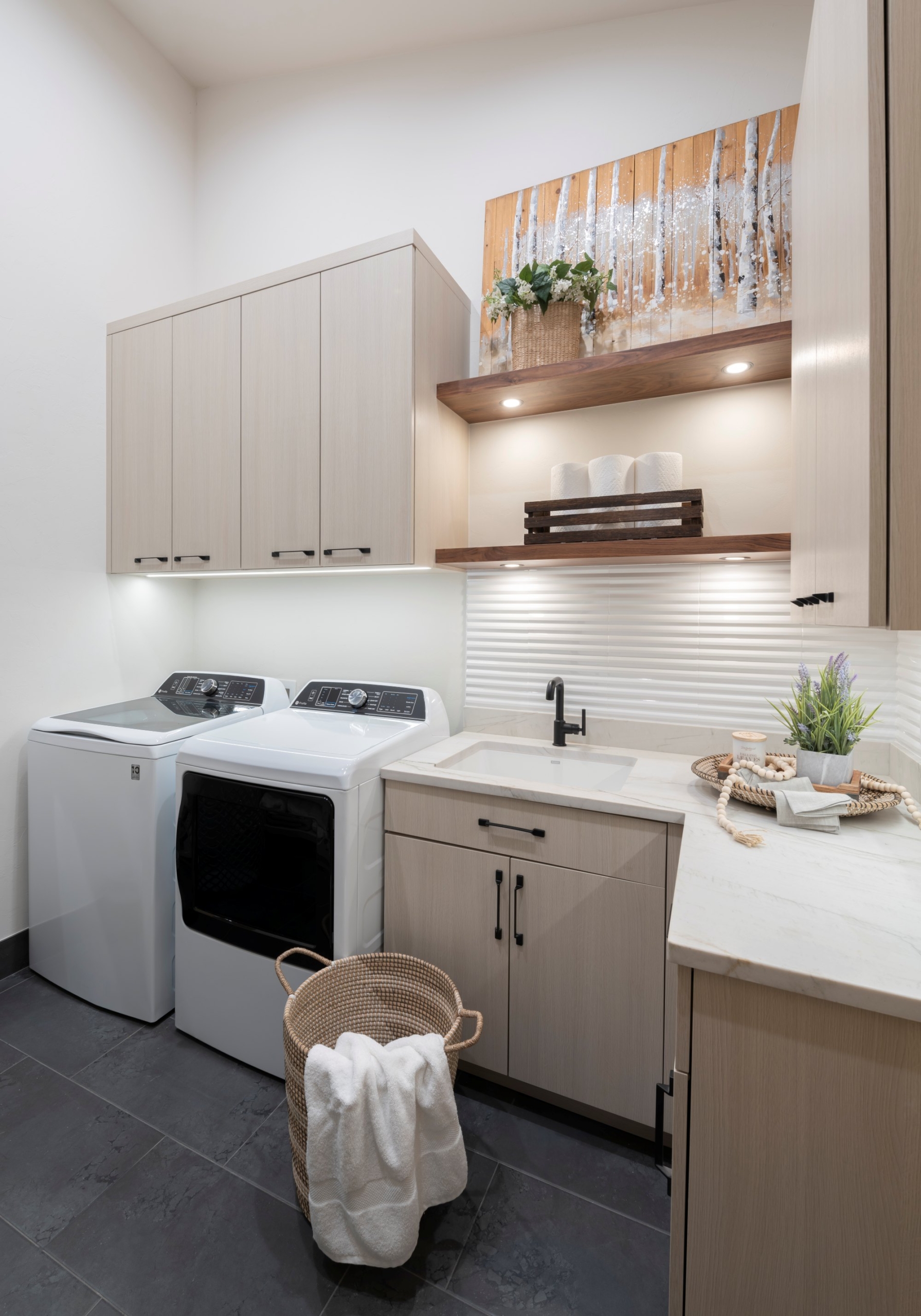 Custom cabinetry for laundry room in this custom home in Arcadia with floating shelves with integrated lighting