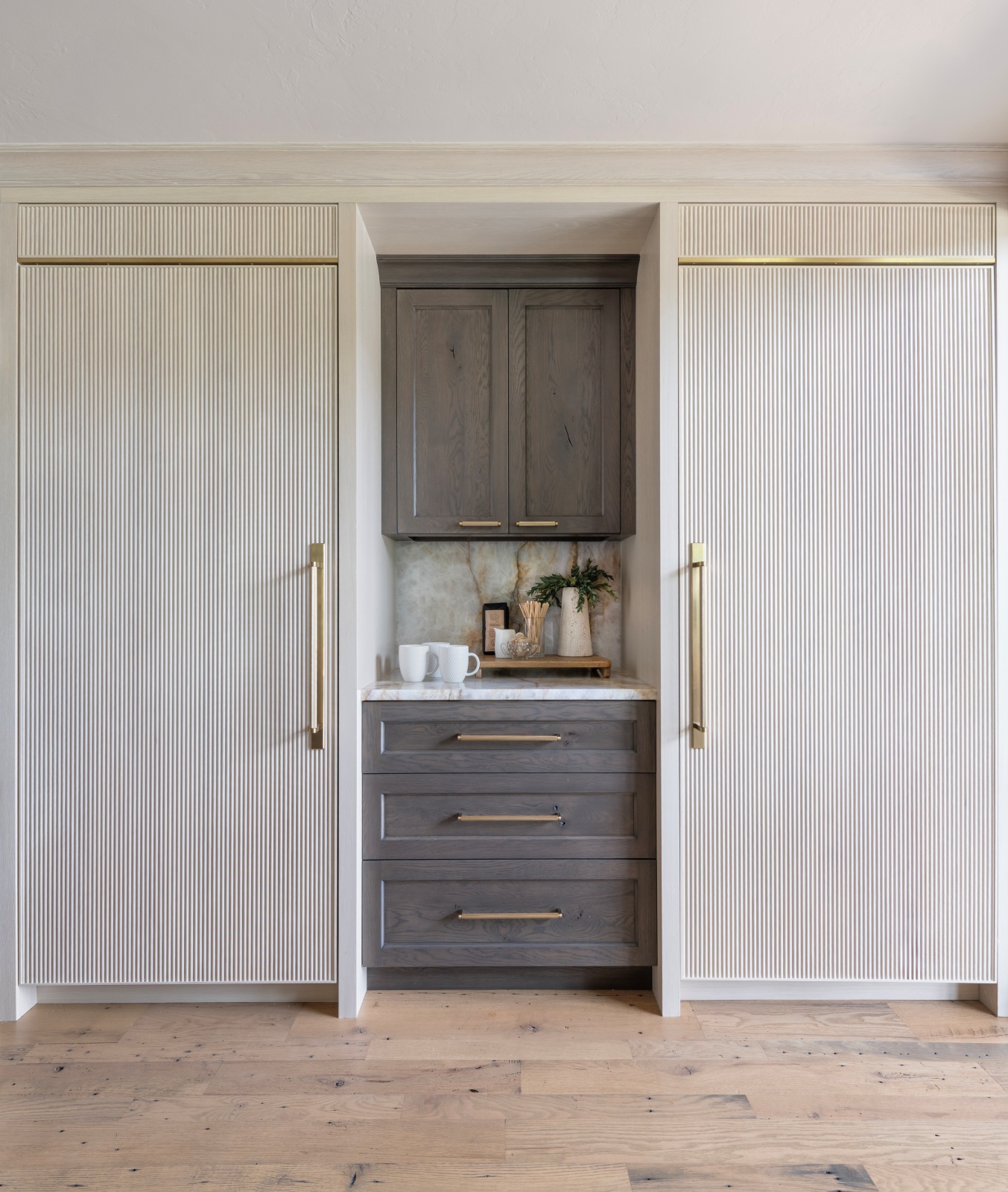 Edmond-kitchen-remodel-coffee-bar-paneled-refrigerator-and-freezer Cabinet composition including our custom reeded appliance panels with gold accents and our rustic knotty oak cabinetry set between for this luxury kitchen remodel