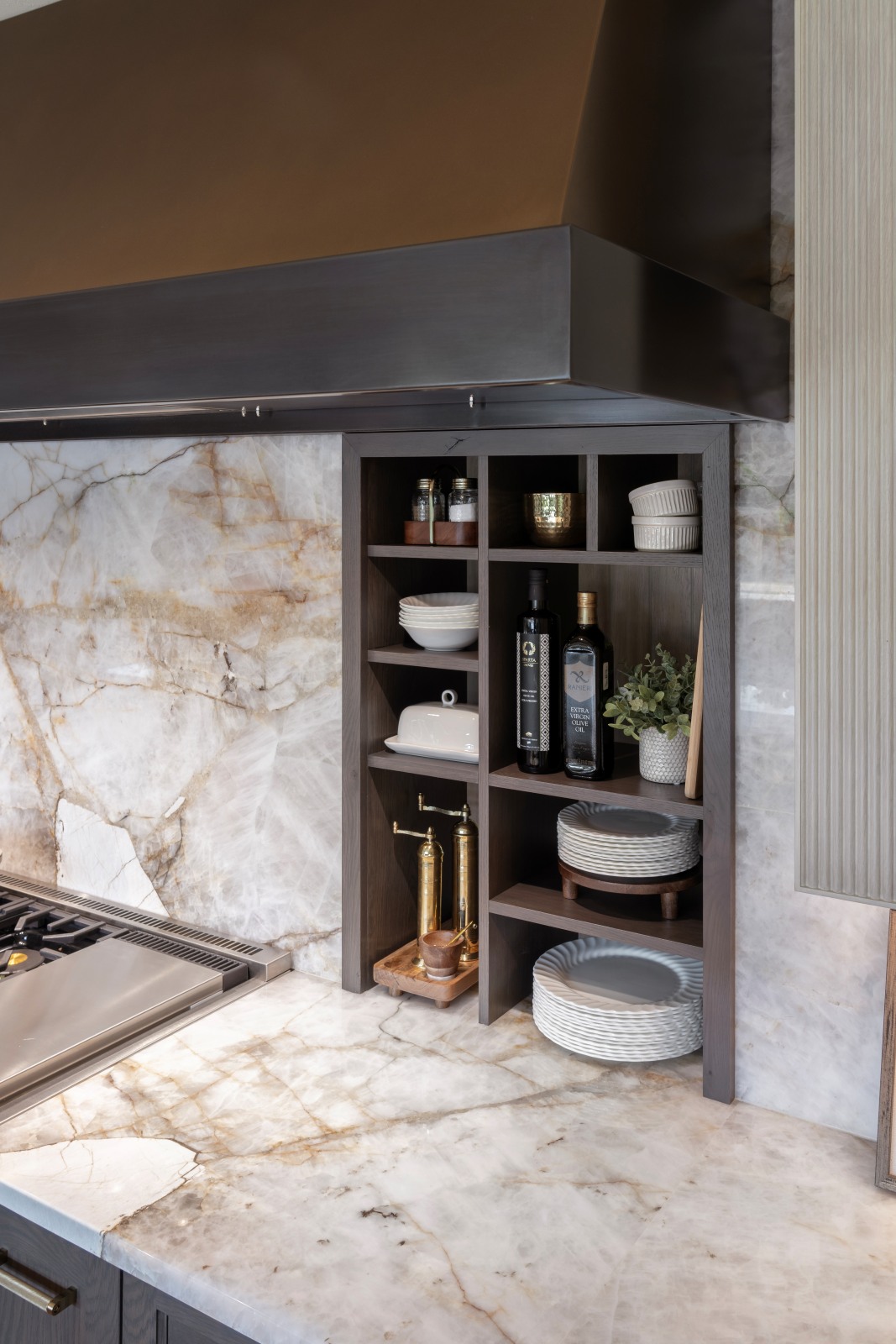 Edmond-kitchen-remodel-recessed-wall-niche-below-venthood Recessed dark-wood storage niche beside the range, integrated into the Crystallo backsplash beneath the custom bronze hood.