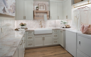 Right-sized laundry room with custom cabinetry, folding counter, sink and integrated hanging rod
