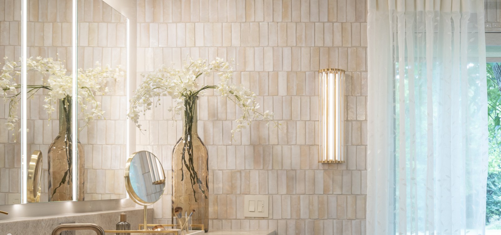 Edmond-primary-bath-remodel-wall-sconce-on-Zellige-tiled-wall Wall sconces were placed on the hand-made Zellige tiled wall in this bathroom remodel in Edmond