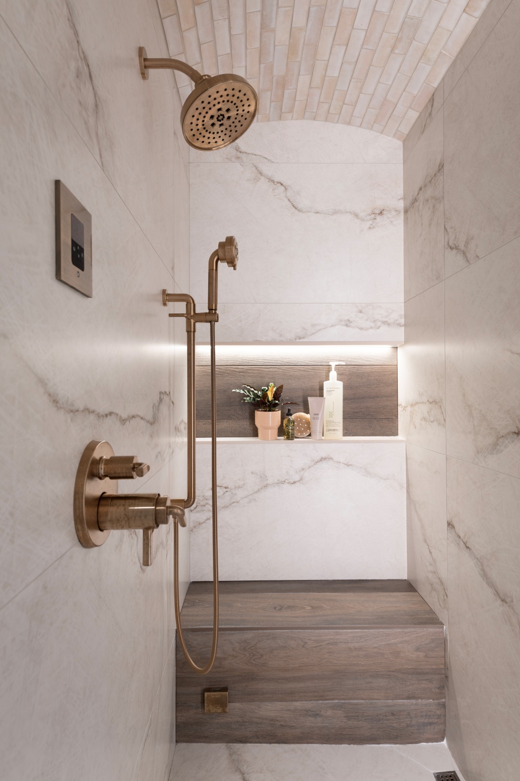 Edmond-steam-shower-remodel-with-infinisty-niche-arched-ceiling-wood-tiled-seat Steam shower with barreled Zellige tile ceiling, wood-look feature wall and frameless glass enclosure
