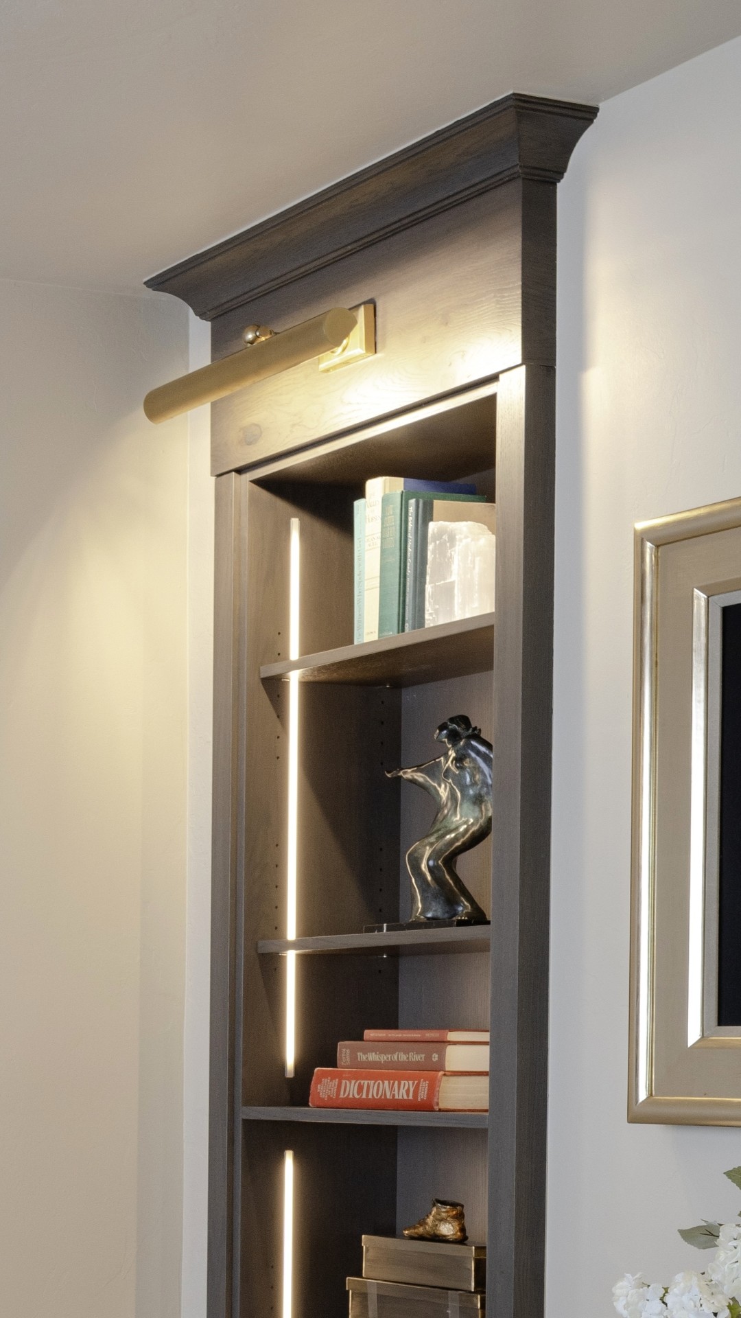 Full-height custom office bookcases with integrated lighting and individual art lights