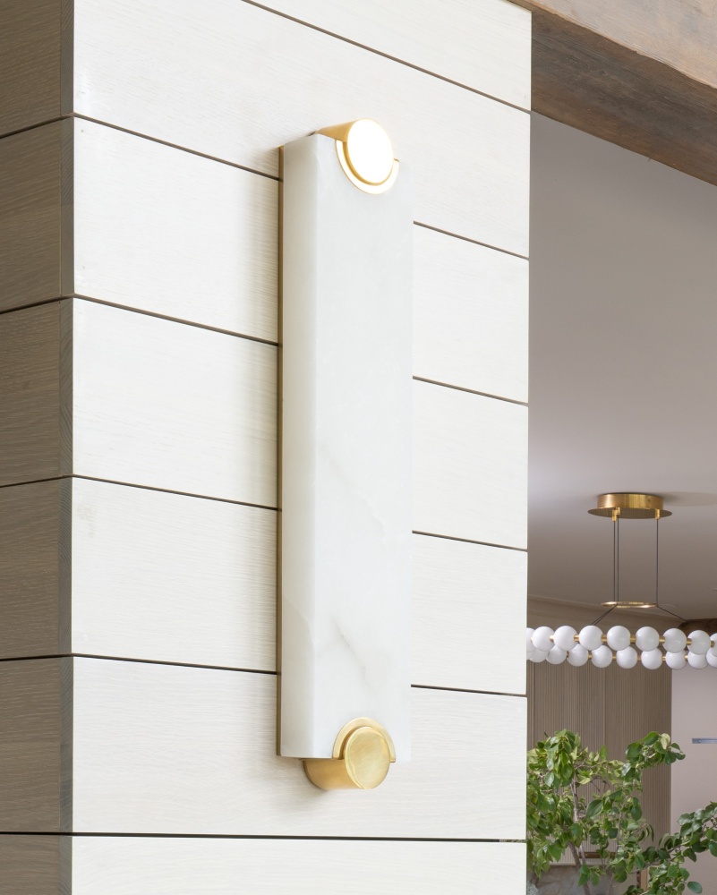 sconces-placed-on-partion-walls-echo-the-stone-and-hardware-used-in-the-remodel